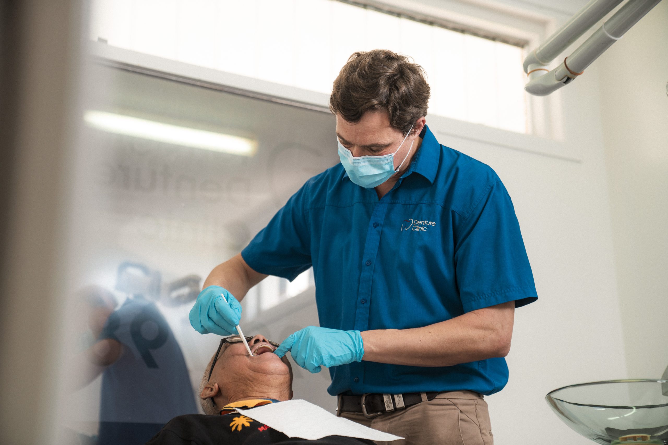 A dental prosthetist treating a patient during denture repair